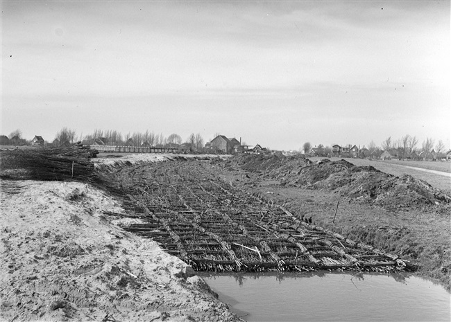 Aanleg van de (drijvende) weg nr. 29 tussen Stolwijk en Bergambacht. Voor het verstevigen van de natte ondergrond wordt een rijzenbed van rijshout gemaakt.
