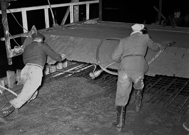 Op een viaduct wordt 's nachts beton gestort.