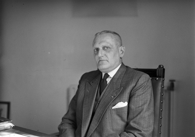 Griffier Helmstrijd in zijn werkkamer in Den Haag, 1956