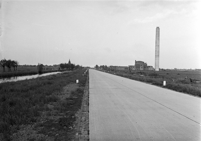 Betonweg (huidige N210) bij Bergambacht. Rechts de schoorsteen van de Haagse Duinwaterleiding en links de kerktoren van Bergambacht.