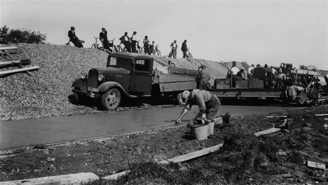 De Provinciale Waterstaat verbetert de weg onderaan de dijk tussen Maassluis en Hoek van Holland. Deze weg loopt evenwijdig aan de provinciale weg, de huidige N220/Maasdijk. De wegverharding van grindbeton wordt afgewerkt. Deze foto is waarschijnlijk gemaakt in de buurt van Maasdijk.