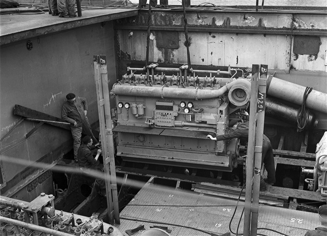 Monteurs plaatsen machine in veerboot Haringvliet, 1957