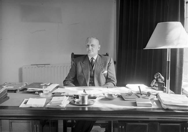 Griffier Helmstrijd in zijn werkkamer in Den Haag, 1956