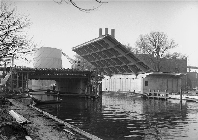 Bouw van de eerste Sint Sebastiaansbrug over het Rijn-Schiekanaal. De basculebrug verbindt de oude binnenstad van Delft met de TU-wijk. Op de achtergrond de gasfabriek, die later is gesloopt.