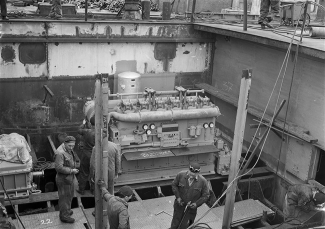 Monteurs plaatsen machine in veerboot Haringvliet, 1957