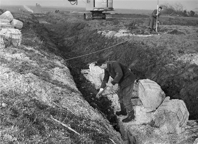 Dijkaanleg door de Provinciale Waterstaat. Schoongemaakte sloten worden opgevuld met houtvezelbalen om een gelijkwaardige ondergrond te krijgen.