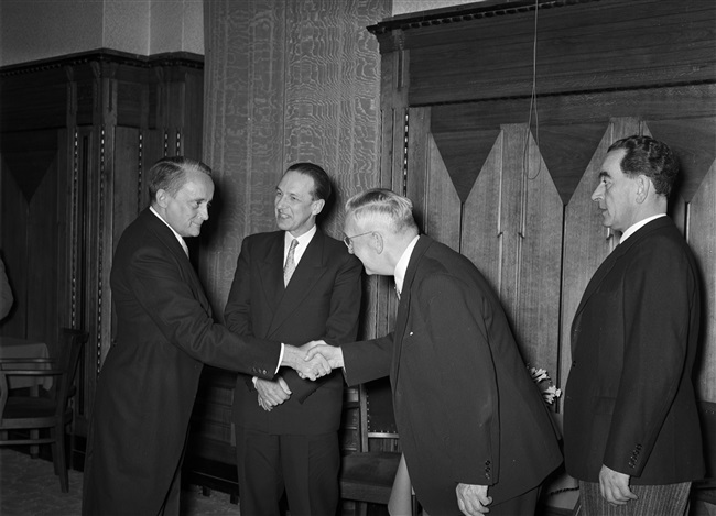 Jan Klaasesz, de nieuwe commissaris van de Koningin (links), schudt de hand van ir. L.T. van der Wal. Naast de commissaris staat prof. ir. J.L. Klein, hoofd-directeur van de Provinciale Waterstaat en de Provinciale Planologische Dienst in Zuid-Holland. De kennismakingsreceptie vindt plaats aan het Korte Voorhout 1.