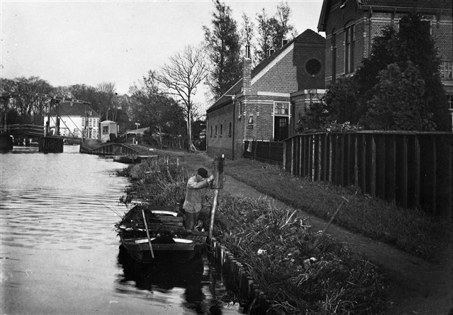 Man slaat perkoenen voor beschoeiing langs de Rijn