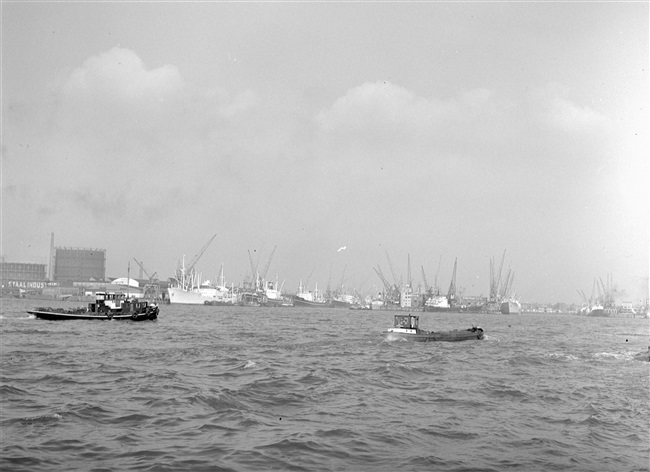 Binnenvaartschepen met op de achtergrond de havens