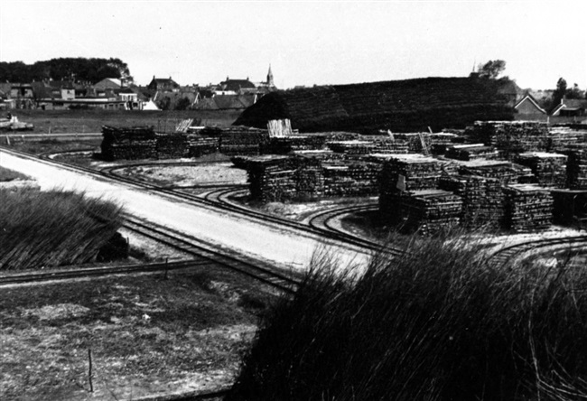 Opslagplaats. Dit materiaal werd waarschijnlijk gebruikt voor het versterken van dijken. De foto is vermoedelijk gemaakt tussen 1950 en 1960.