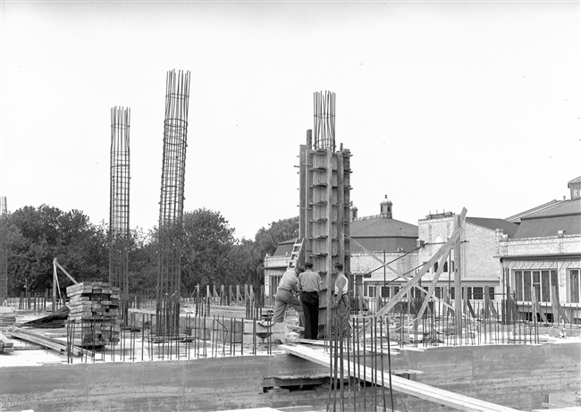 De wapening en een bekisting voor de betonkolommen op de eerste verdieping van het nieuwe provinciehuis. Rechts het restaurant van de voormalige Haagsche Dierentuin.