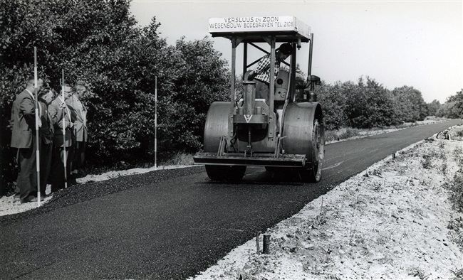 Aanleg fietspad nr. 18. Het asfalt wordt verdicht met een wals door een walsmachinist van Versluys en Zoon Wegenbouw uit Bodegraven. Door het aanleggen van fietspaden ontsluit de provincie Zuid-Holland gebieden voor recreatie.