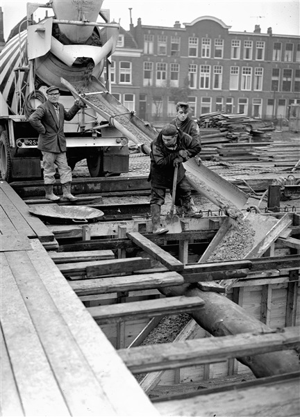 Een betonstorter stort beton in de bekistingen voor de keldervloer en de wanden van de eerste St. Sebastiaansbrug.