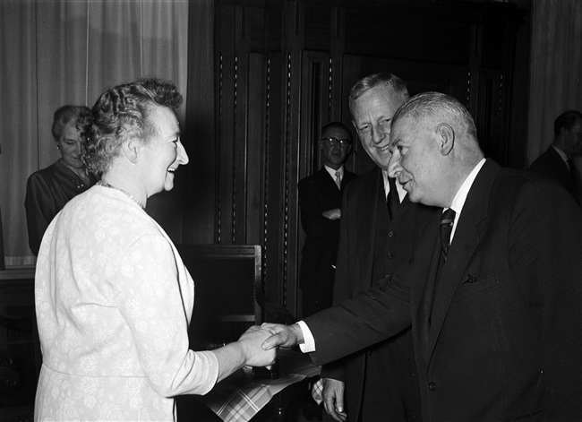 Gedeputeerde A.C.A. Deerenberg schudt mevrouw Stegeman de hand bij haar ambtsjubileum en afscheid, aan het Korte Voorhout 1.