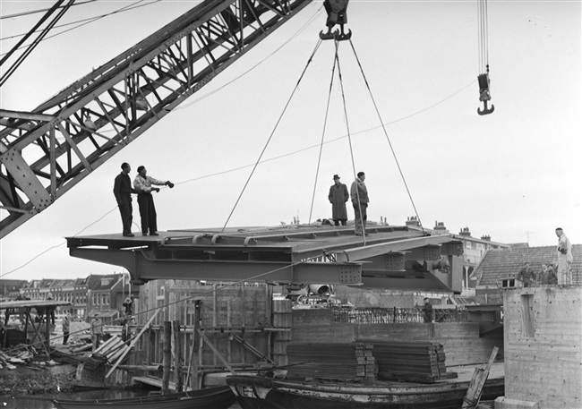 Een drijvende bok plaatst de bovenbouw van de Oude Tolbrug die wordt vernieuwd. De basculebrug over het Rijn-Schiekanaal komt tussen de Westvlietweg en de Fonteynenburghlaan.