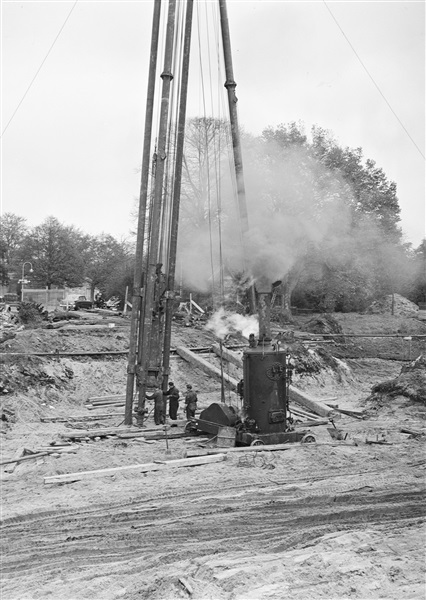 Een paal wordt in de grond geslagen voor de fundering van de hoogbouw van het nieuwe provinciehuis, aan de Koningskade.