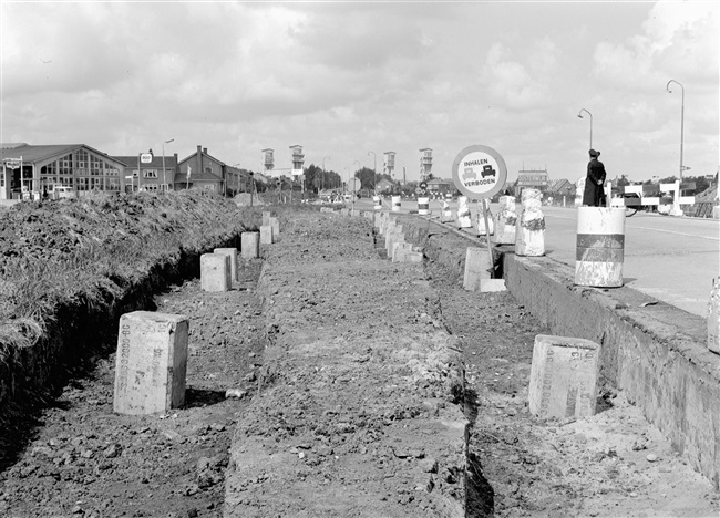 Verruiming van een kruising in de Tiendweg. De fundering bestaat uit palen van gewapend beton, waarop een betonweg komt te liggen.