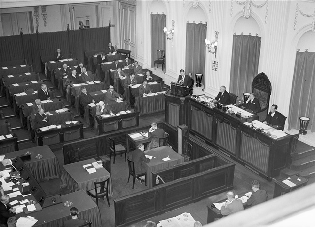 De Provinciale Staten vergaderen in de Tweede Kamer. Jan Klaasesz, commissaris van de Koningin, zit de vergadering voor.