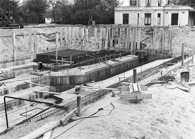 De betonfundering wordt gemaakt van het in aanbouw zijnde provinciehuis. Op de achtergrond het voormalige directiegebouw van de Haagsche Dierentuin.