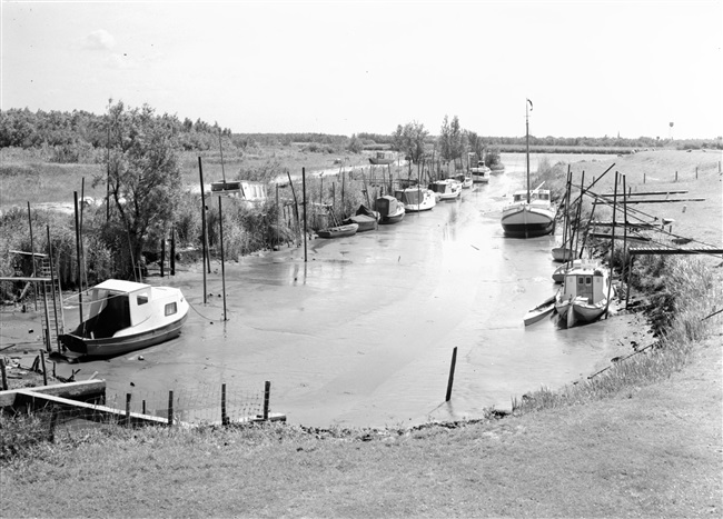 Getijdenhaventje dat is drooggevallen bij laagwater