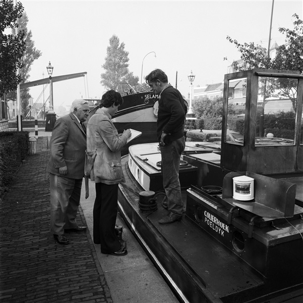 Een ambtenaar telt de boten bij de sluis in Leidschendam