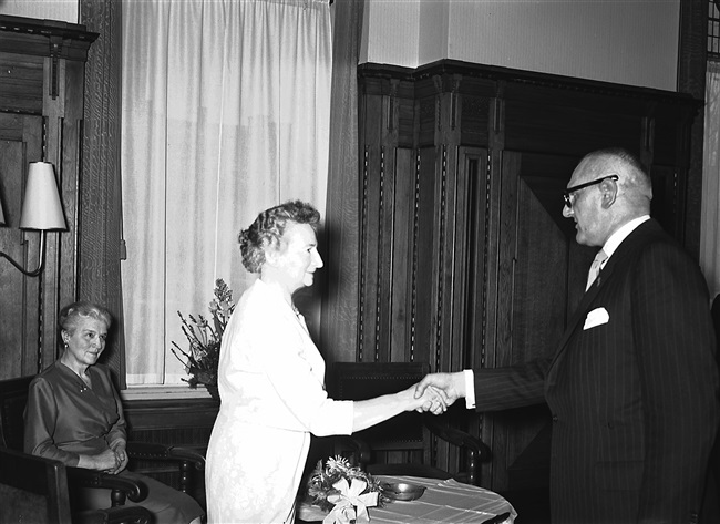 De heer mr. F.A. Helmstrijd, griffier van de Provinciale Staten van Zuid-Holland, schudt mevrouw Stegeman de hand bij haar ambtsjubileum en afscheid, aan het Korte Voorhout 1.