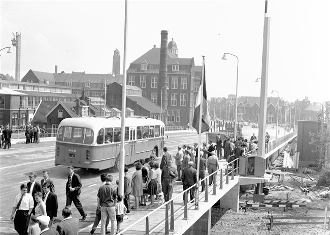 Opening van de eerste St. Sebastiaansbrug over het Rijn-Schiekanaal. De basculebrug verbindt de oude binnenstad van Delft met de TU-wijk. Links het voormalige laboratorium van de Afdeling Physica en Electrotechniek van de Polytechnische School.