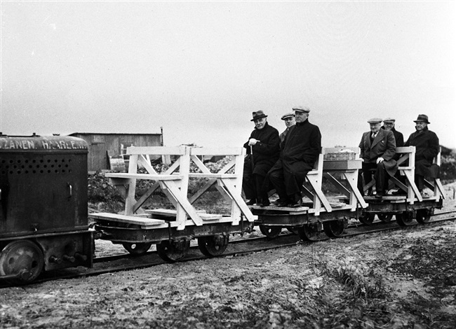 Bestuurders en/of ambtenaren van de provincie Zuid-Holland bekijken vanaf een lorrie een project van Provinciale Waterstaat. De foto is waarschijnlijk gemaakt tussen 1946 en 1952.