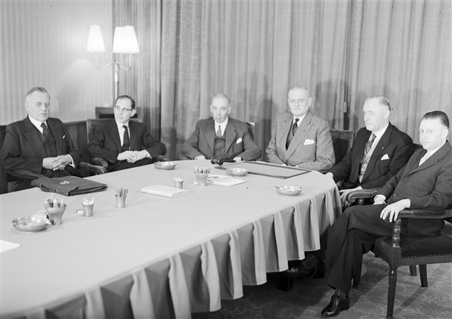 Vergadering van de Provinciale Griffie. Aan de kop van de tafel mr. F.A. Helmstrijd, griffier van de Provinciale Staten van Zuid-Holland.