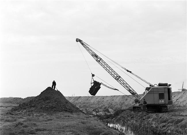 Dijkherstel bij Stellendam na de watersnoodramp van 1 februari 1953. Met behulp van een dragline wordt een nieuw dijklichaam gevormd.