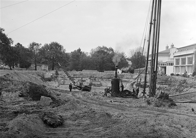 Heiwerkzaamheden voor de bouw van de hoogbouw, van het nieuwe provinciehuis. Op het terrein staan nog gebouwen van de voormalige Haagsche Dierentuin.