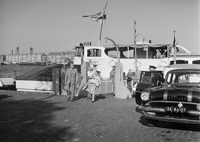 De Provinciale Staten op excursie naar Rotterdam, de Brielse Maas en de Deltawerken. Aan het einde van de dag verlaten de Statenleden de Prinsesseplaat van de Spido. Links de commissaris van de Koningin Jan Klaasesz. Rechts een dienstauto van de provincie Zuid-Holland.