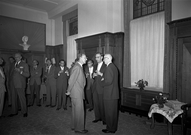 Ambtsjubileum van de heer Ormel, medewerker van de provincie Zuid-Holland, aan het Korte Voorhout 1. Prof. ir. J.L. Klein feliciteert Ormel. Klein was hoofd-directeur van de Provinciale Waterstaat en de Provinciale Planologische Dienst in Zuid-Holland.