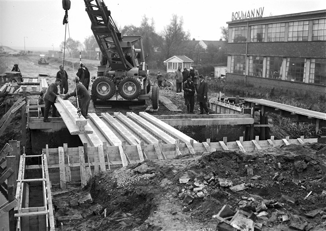 Aanleg van een weg op zandpalen (Abram van Rijckevorselweg) in het voormalige dorp Kralingse Veer. Rechts firma Bouman N.V.