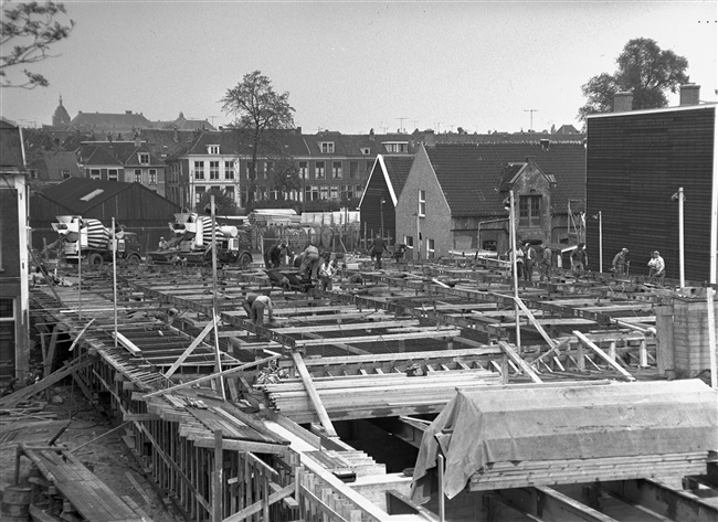 Betontimmermannen storten beton in de bekisting voor het noordelijke viaduct. Het viaduct is onderdeel van de eerste St. Sebastiaansbrug.
