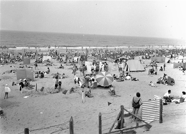 Mensen op het strand bij Hoek van Holland. De provincie Zuid-Holland maakt stranden beter bereikbaar door het aanleggen of verbeteren van wegen ernaartoe.
