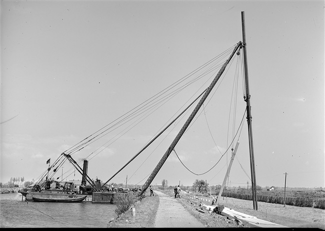 Drijvende bok plaatst heipalen bij aanleg S25/N207, 1955