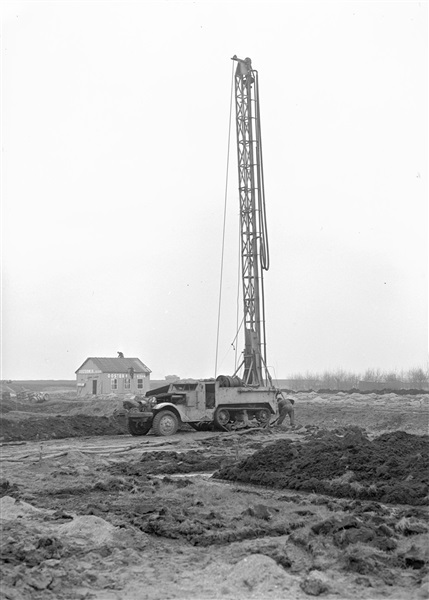 Aanleg van een weg op zandpalen. Een boormachine boort gaten die met grindzand worden opgevuld. Deze fundering van zandpalen vergroot de draagkracht van de bodem en voorkomt dat de wegverharding verzakt.