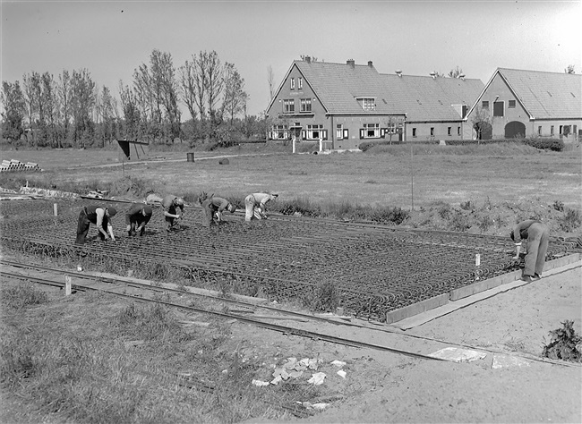 Aanleg van de weg op palen tussen Boskoop en Alphen aan den Rijn. IJzervlechters vlechten het wapeningsstaal voor de platen.