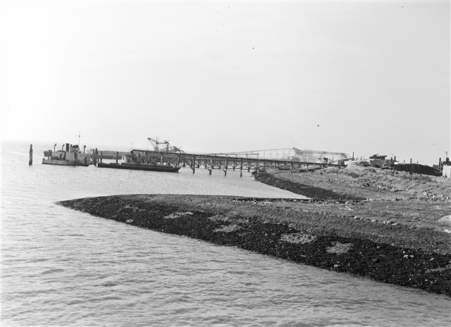 De dijk bij de Hoek van Sint Jacob op Goeree-Overflakkee wordt hersteld na de watersnoodramp van 1 februari 1953. Zand en water worden via een buis geperst naar de plek waar een nieuw dijklichaam wordt opgespoten.