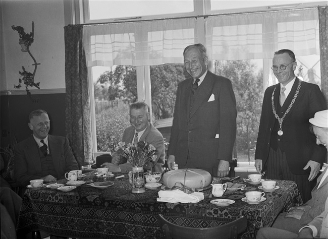 Werkbezoek van de Provinciale Staten van Zuid-Holland. Willem Timmerman, burgemeester van Meerkerk, biedt een kaas aan. Links van hem Lodewijk Albert Kesper, commissaris van de Koningin.