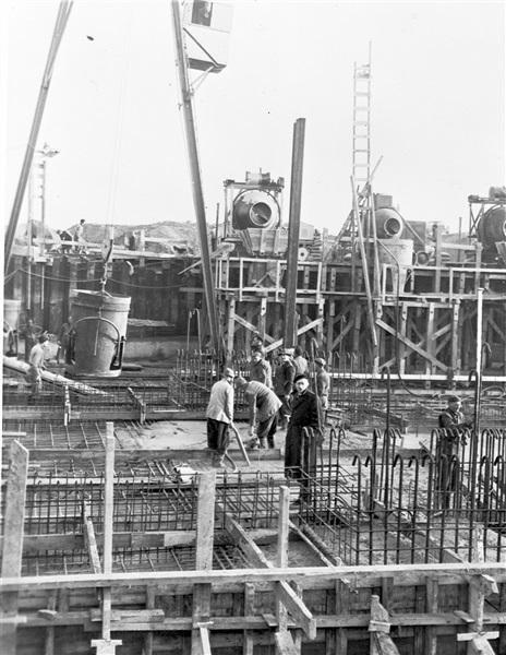 Bouw van een sluis bij Oude-Tonge. In de wapening wordt beton gestort en aangetrild met een pneumatische vibrator.