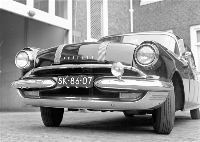 Een dienstauto van de provincie Zuid-Holland voor de garage aan de Schouwburgstraat. De foto van de Pontiac werd gebruikt in het verslag van de eerste provinciale Verkeersdag.