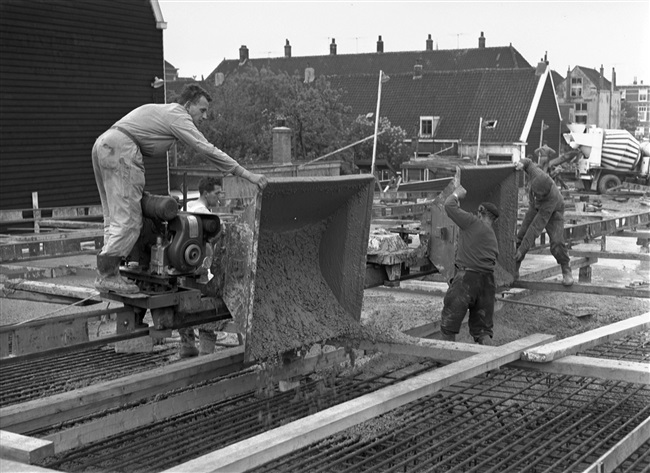 Betontimmermannen storten beton in de bekisting voor het noordelijke viaduct. Het viaduct is onderdeel van de eerste St. Sebastiaansbrug.